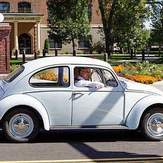 John McVay driving a light blue beetle